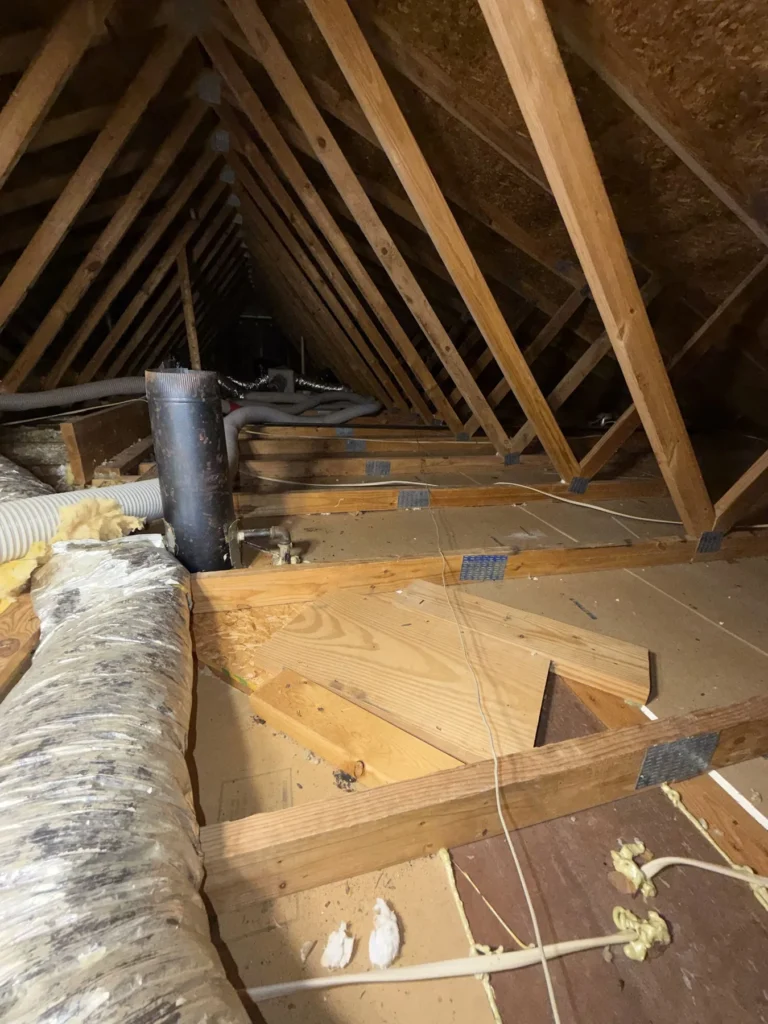 Attic with ductwork and insulation between the joists