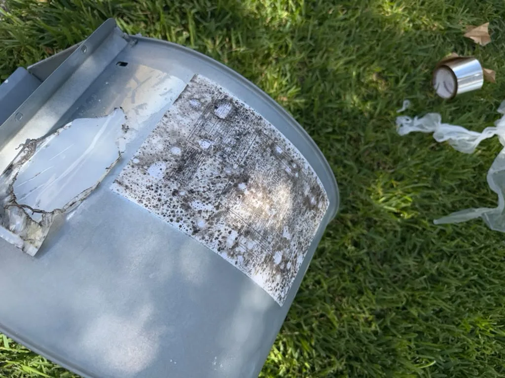 Blower housing panel coated in dust before cleaning