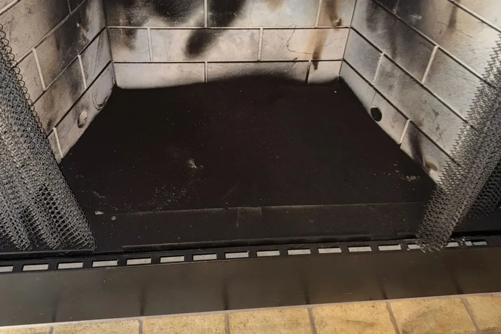 Clean fireplace firebox after a chimney inspection and sweep