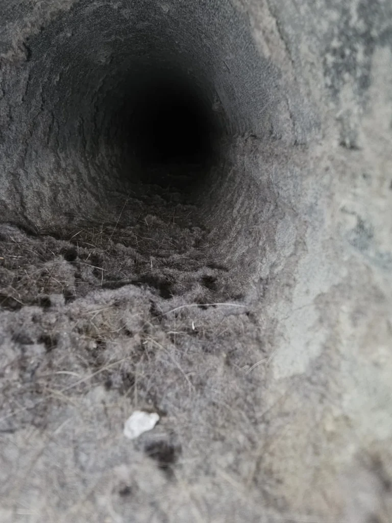Lint build-up inside a vertical dryer vent duct before cleaning
