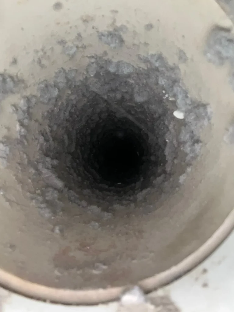 Lint lining the inside of a dryer vent duct before cleaning