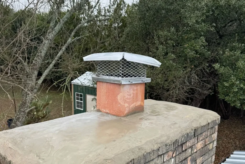 New stainless chimney cap installed on a brick chimney