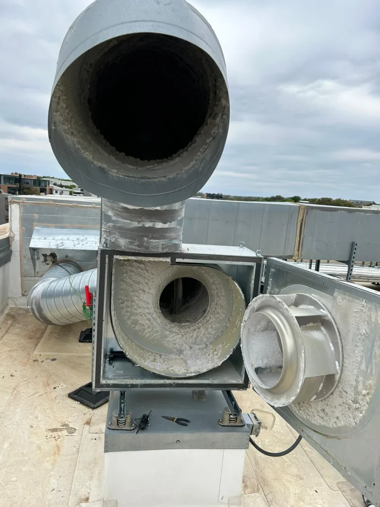 Rooftop dryer exhaust fan with lint inside the housing before cleaning