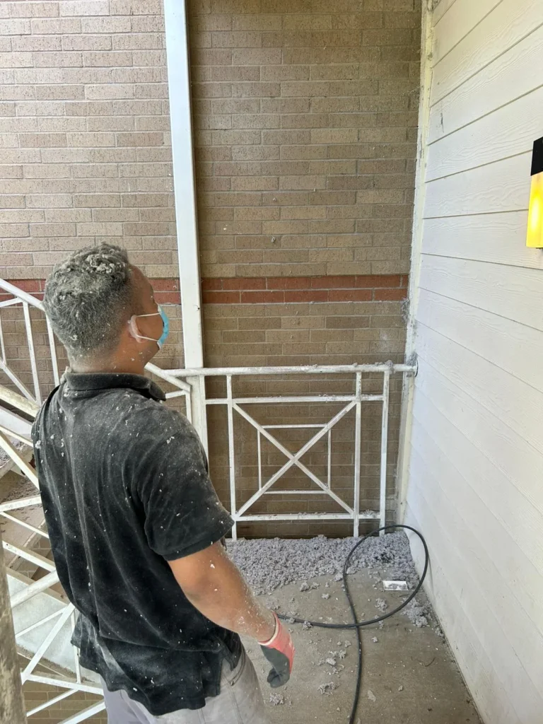Technician cleaning a dryer vent with lint removed onto the patio