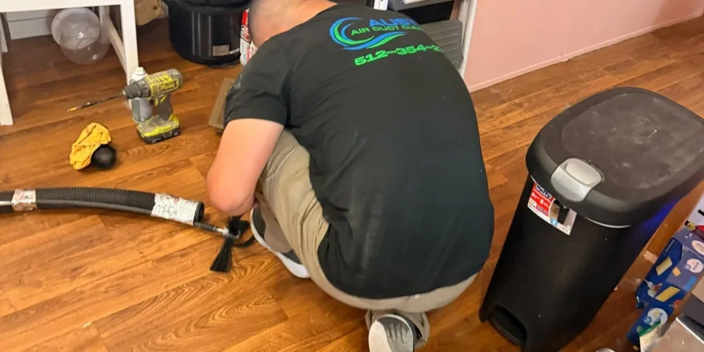 Technician setting up duct cleaning equipment inside a home
