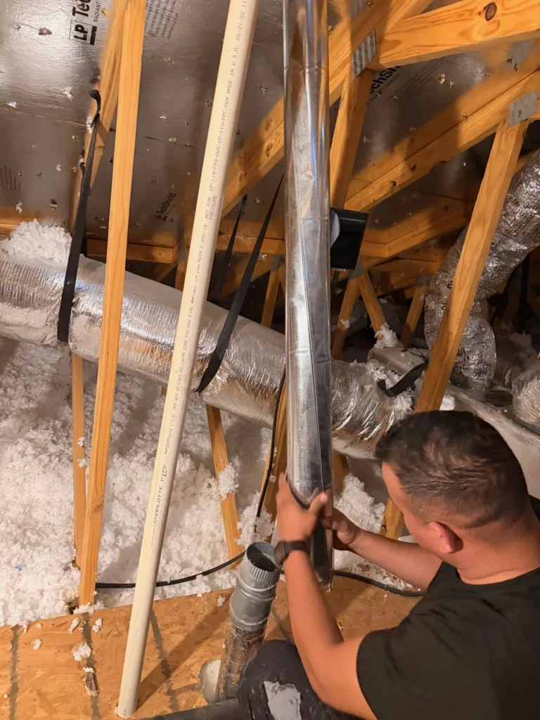 Technician working on a dryer vent run in an attic